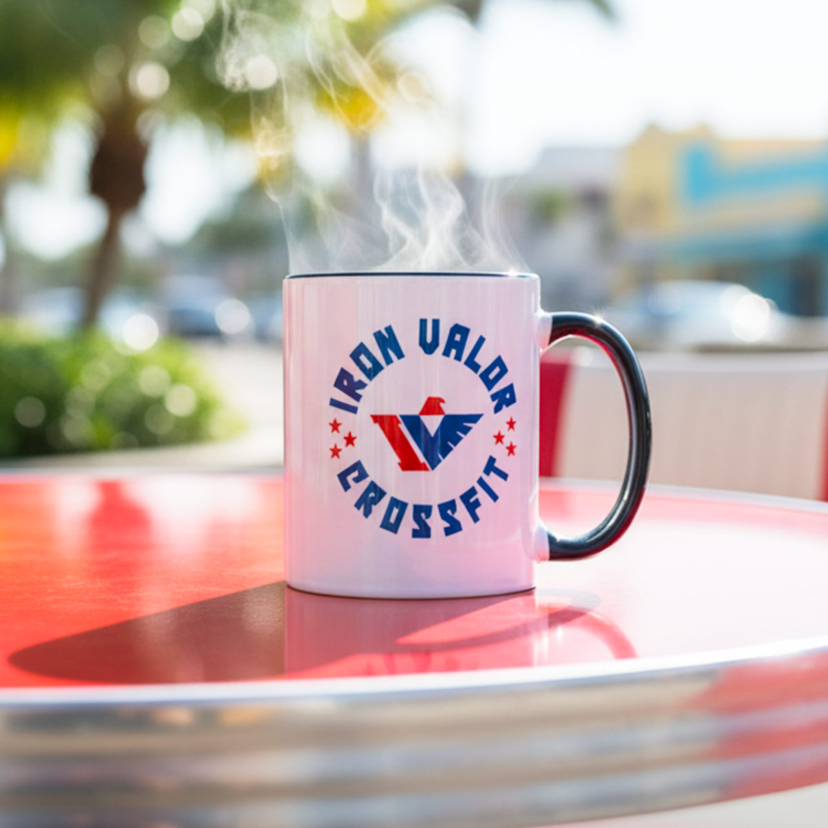 Pink mug with 'Iron Valor CrossFit' logo on a red table outdoors