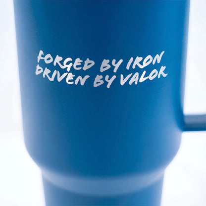 Blue mug with white text 'FORGED BY IRON DRIVEN BY VALOR' on a white background